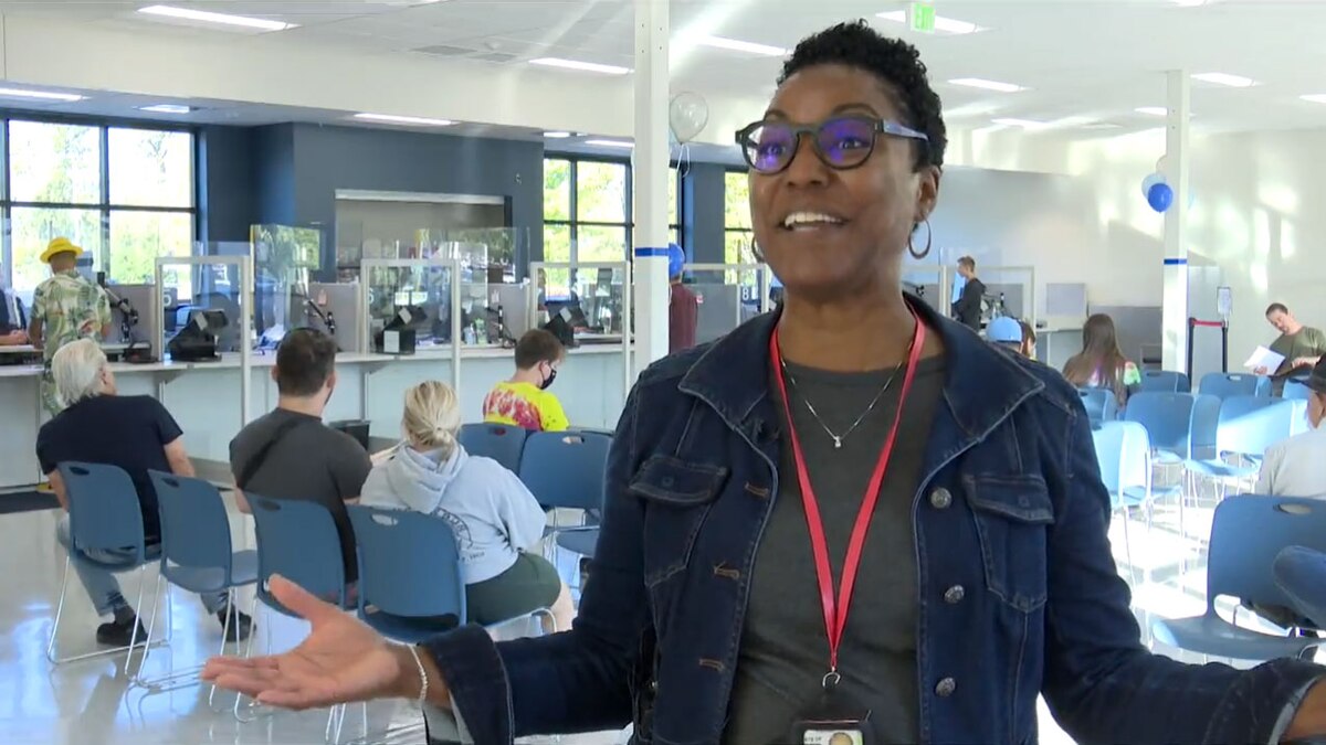 Office Manager Standing in the Office with Her Arms Outstretched Like She is Welcoming You