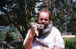 Boa Constrictor asa Pet Wrapped Around a Man's Neck and he is Holding the snake's Head so the camera Can See I. The Man is Smiling Boa Constrictor asa Pet Wrapped Around a Man's Neck and he is Holding the snake's Head so the camera Can See I. The Man is Smiling