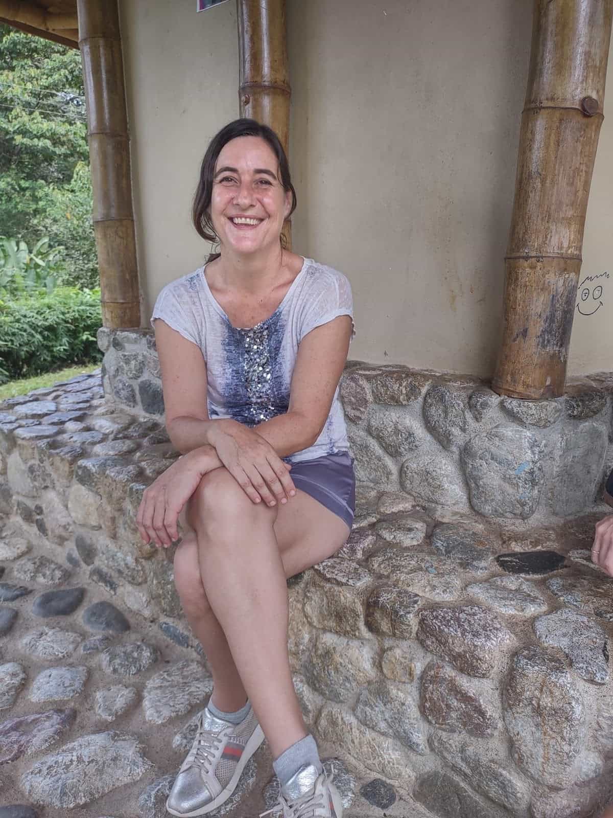 Esther Sitting in Front of Salon Eco Cultural Dos Brazos de Río Tigre Smiling Broadly