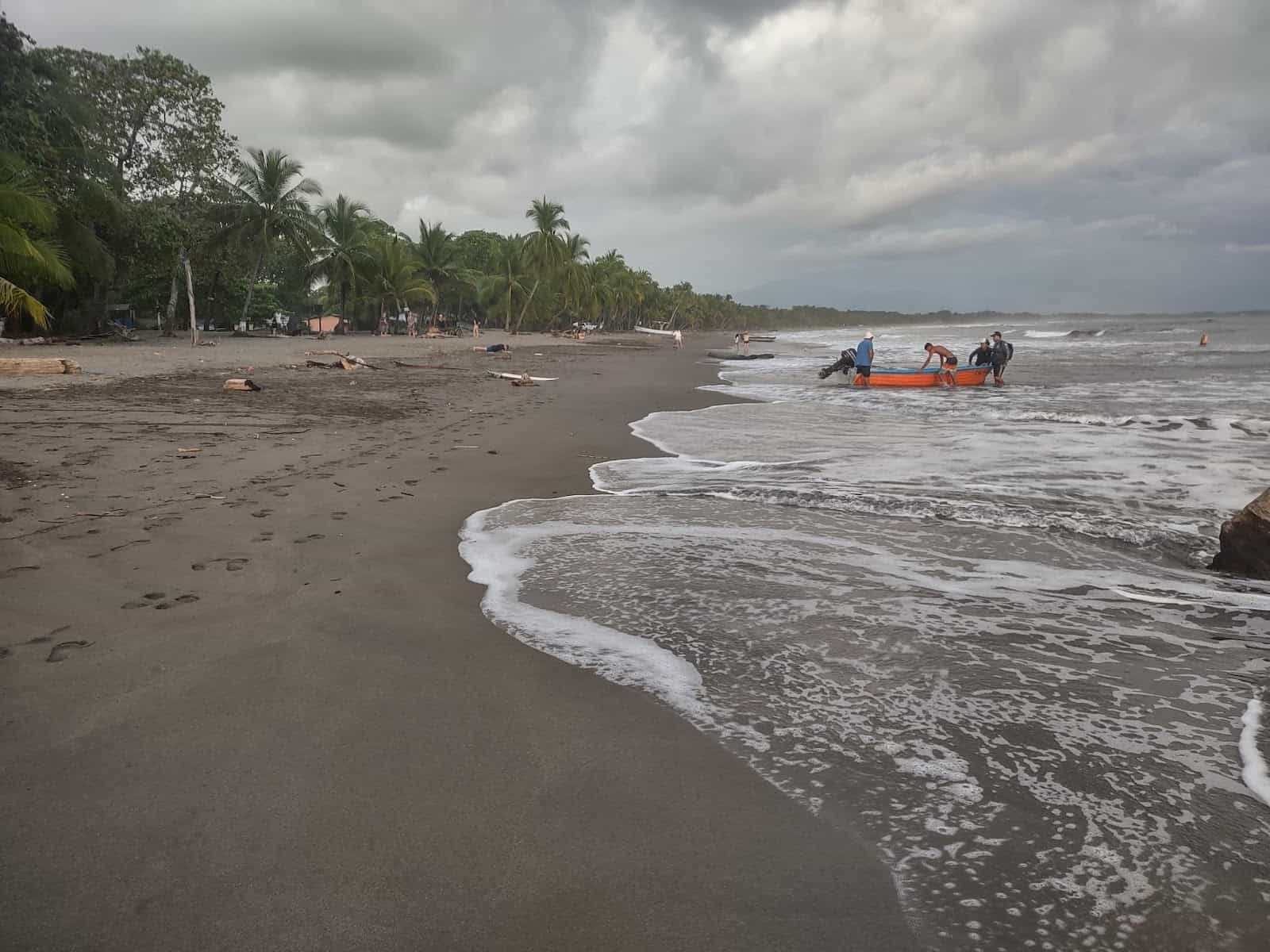 People Bringing a Boat to Shore at the Beach in Esterillos Oeste