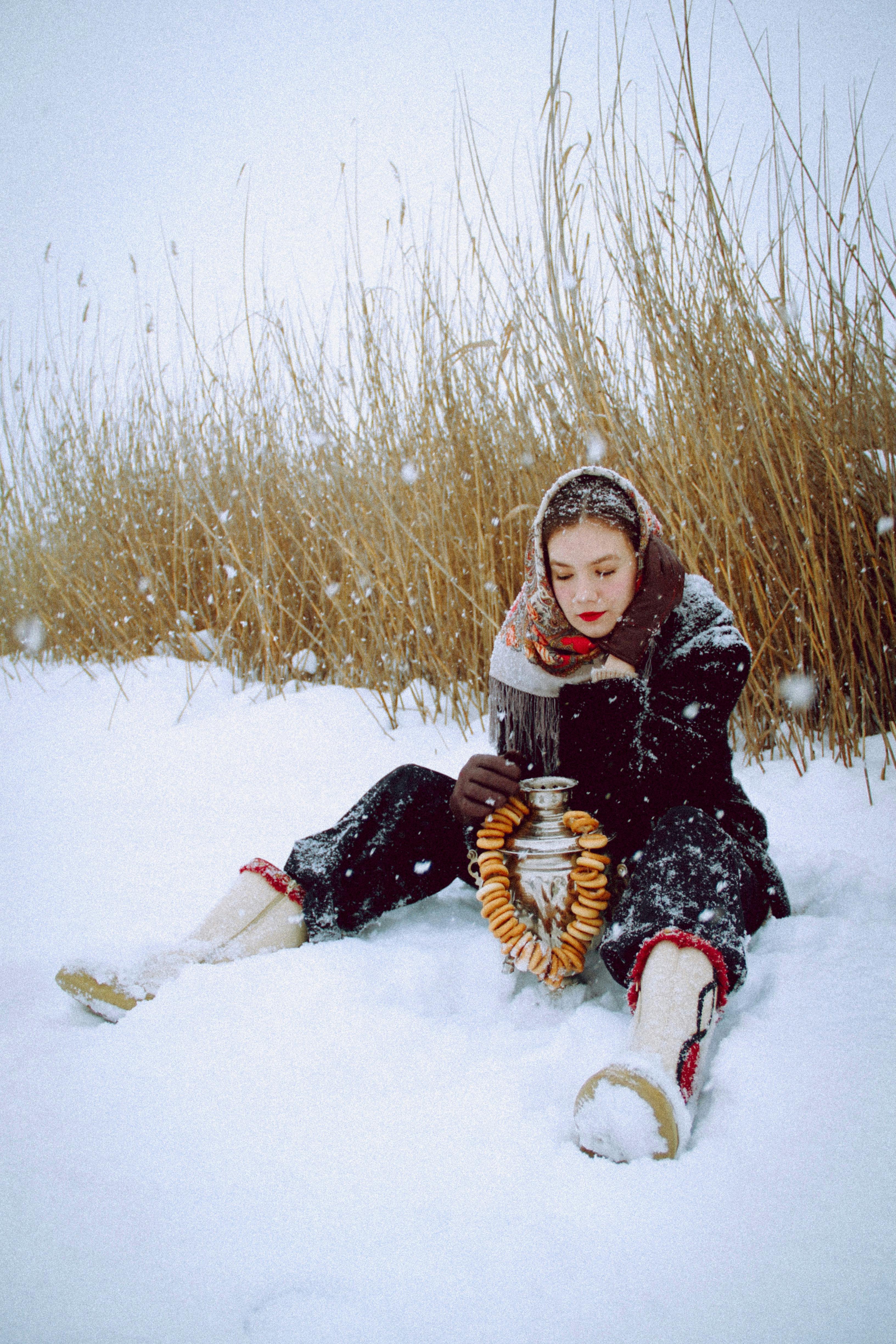 A Woman Dressed for Winter Sitting in the Snow With an Urn A Woman Dressed for Winter Sitting in the Snow With an Urn