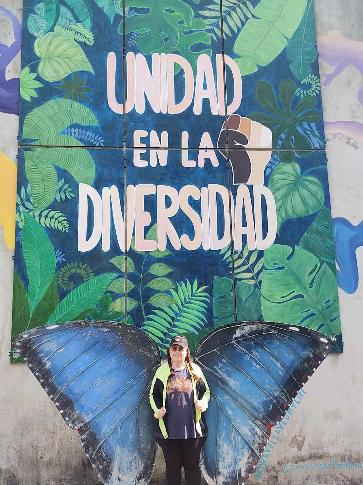 A Wall Mural Saying Unidad En La Diversidad. At the Bottom Is Butterfly Wings and I Am Standing There so That It Looks Like I Am a Butterfly A Wall Mural Saying Unidad En La Diversidad. At the Bottom Is Butterfly Wings and I Am Standing There so That It Looks Like I Am a Butterfly